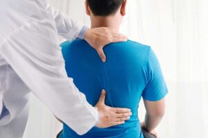 A chiropractor discusses spine health with a patient in a bright, welcoming clinic.