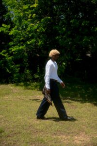 Adult using safe lifting technique with bent knees while moving a storage box.
